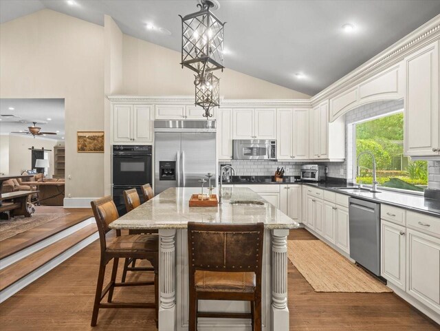 kitchen with black appliances, a sink, ceiling fan, and backsplash