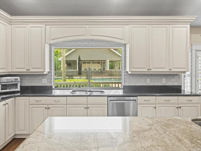 kitchen with a wealth of natural light, stainless steel dishwasher, backsplash, and a sink