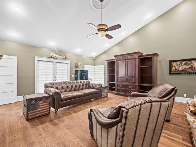 living area with lofted ceiling, wood finished floors, and a ceiling fan