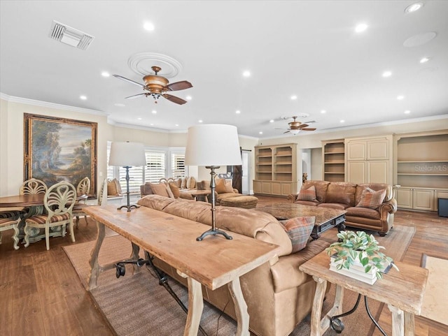 living area featuring visible vents, ornamental molding, a ceiling fan, and light wood-style floors
