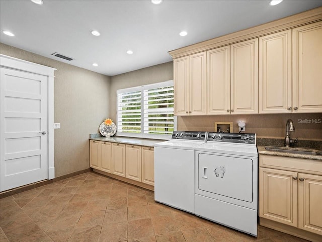 washroom with washing machine and clothes dryer, a sink, visible vents, recessed lighting, and cabinet space
