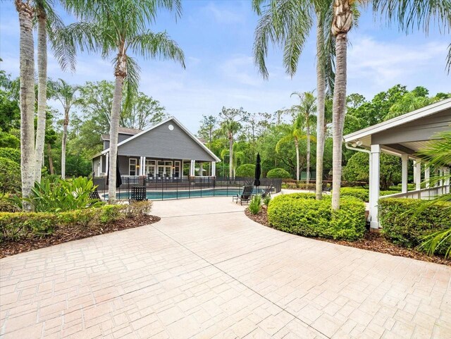 surrounding community with a patio, fence, and a swimming pool