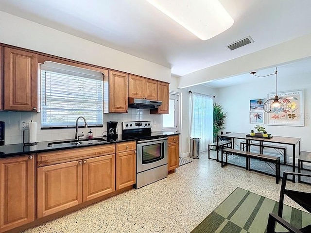 kitchen featuring dark countertops, under cabinet range hood, visible vents, stainless steel electric stove, and a sink