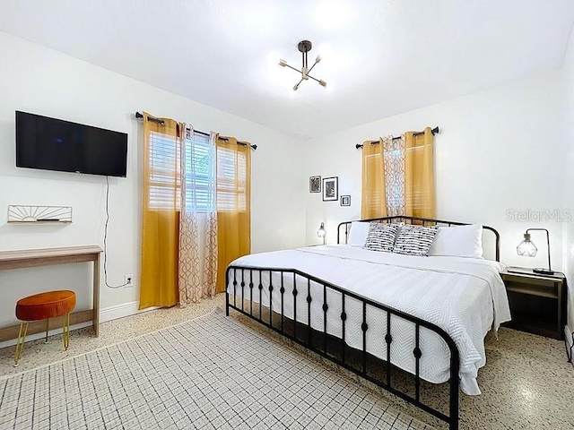 bedroom with speckled floor and baseboards