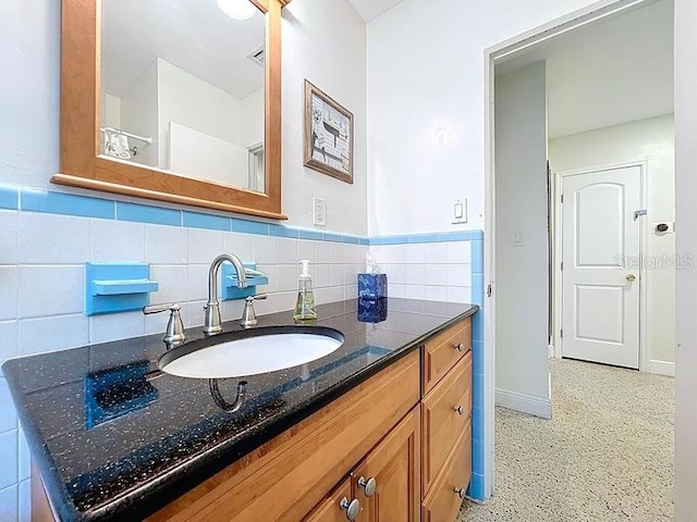 bathroom with vanity, baseboards, and speckled floor