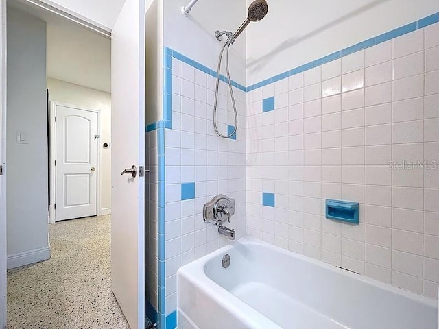 bathroom featuring speckled floor, baseboards, and  shower combination