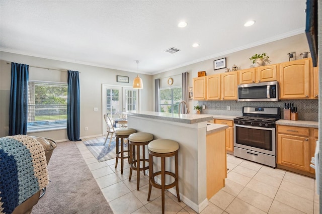 11519 Cypress Reserve Dr, Tampa, FL 33626 - kitchen featuring light tile patterned floors, visible vents, light countertops, appliances with stainless steel finishes, and decorative backsplash