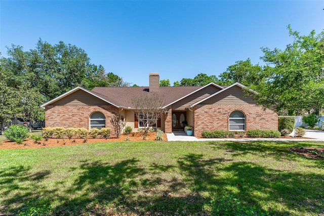 single story home with brick siding, a front lawn, and a chimney