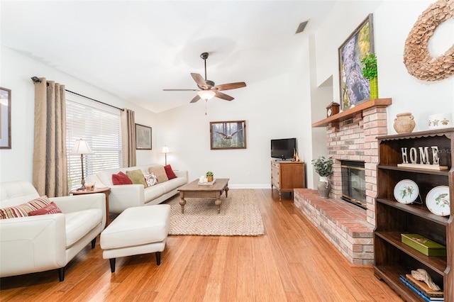 living room featuring visible vents, ceiling fan, light wood-type flooring, a fireplace, and vaulted ceiling