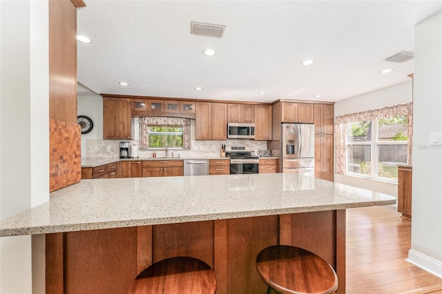 kitchen with visible vents, brown cabinetry, and stainless steel appliances
