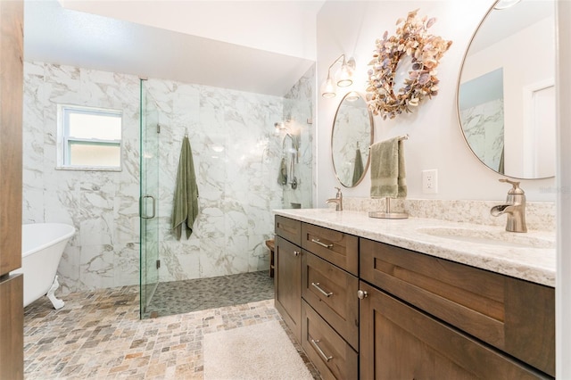 bathroom featuring a sink, a marble finish shower, a soaking tub, and double vanity
