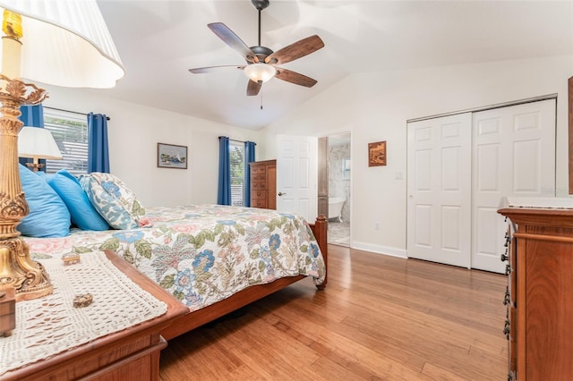 bedroom featuring baseboards, light wood-type flooring, vaulted ceiling, a closet, and a ceiling fan