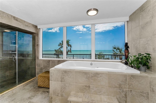 1600 Gulf Blvd Unit 212, Clearwater Beach, FL 33767 - bathroom featuring a garden tub, a water view, a stall shower, and tile walls