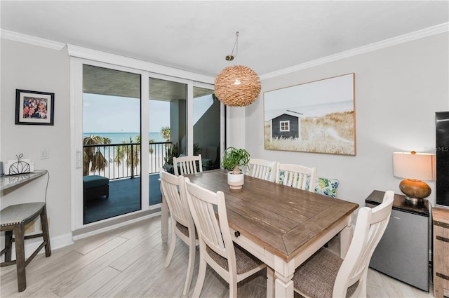 1600 Gulf Blvd Unit 212, Clearwater Beach, FL 33767 - dining area with light wood-style floors, ornamental molding, baseboards, and a water view