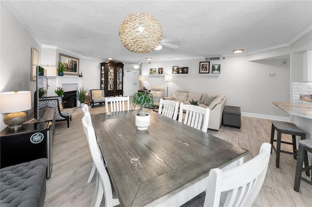 1600 Gulf Blvd Unit 212, Clearwater Beach, FL 33767 - dining room featuring ceiling fan, ornamental molding, baseboards, and a fireplace