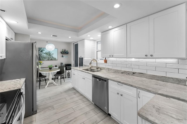 1600 Gulf Blvd Unit 212, Clearwater Beach, FL 33767 - kitchen with recessed lighting, white cabinetry, tasteful backsplash, a sink, and stainless steel appliances