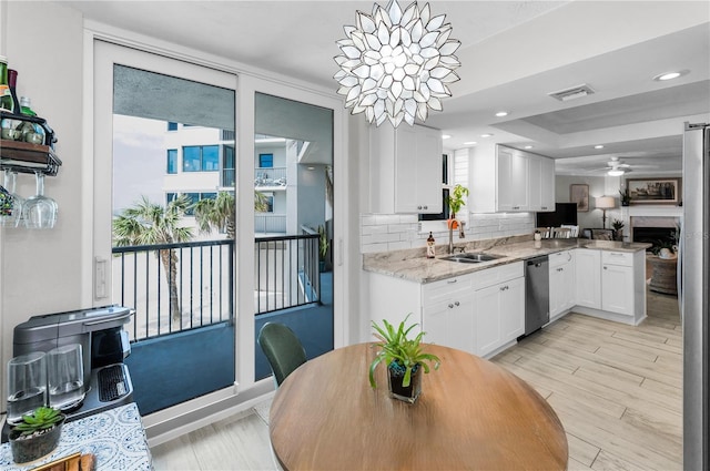 1600 Gulf Blvd Unit 212, Clearwater Beach, FL 33767 - kitchen with decorative backsplash, visible vents, appliances with stainless steel finishes, a sink, and white cabinetry