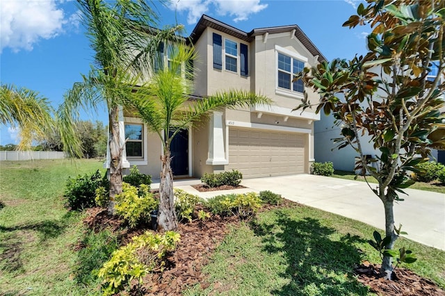 view of front of house with a garage, a front yard, driveway, and stucco siding