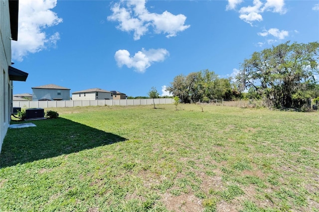 view of yard featuring central AC unit and fence