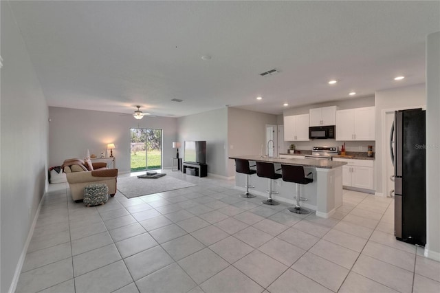 kitchen with a breakfast bar, open floor plan, visible vents, appliances with stainless steel finishes, and a sink