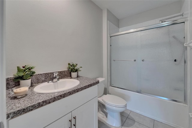full bath featuring tile patterned floors, enclosed tub / shower combo, vanity, and toilet
