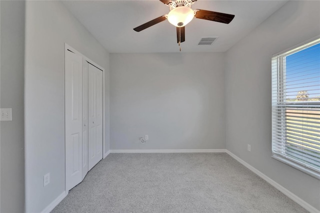unfurnished bedroom featuring visible vents, baseboards, multiple windows, and carpet flooring