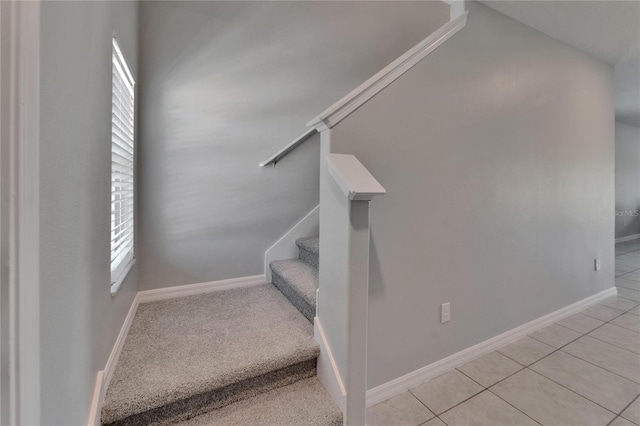 stairway with baseboards and tile patterned flooring