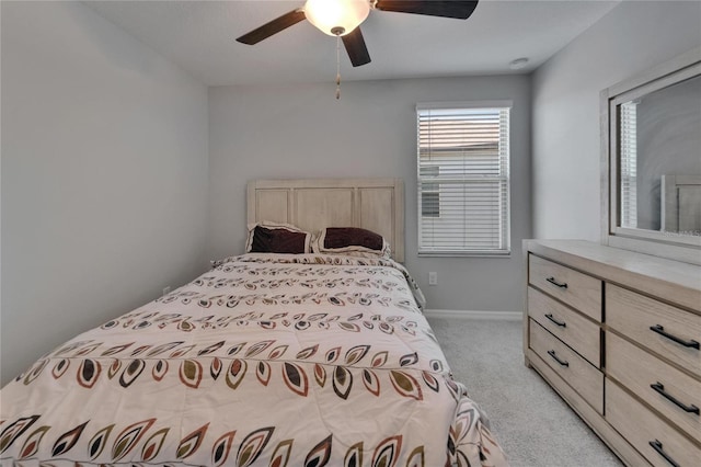 bedroom featuring light carpet, baseboards, and a ceiling fan
