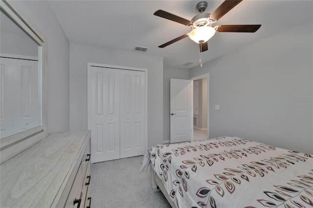bedroom featuring visible vents, ceiling fan, a closet, and light carpet
