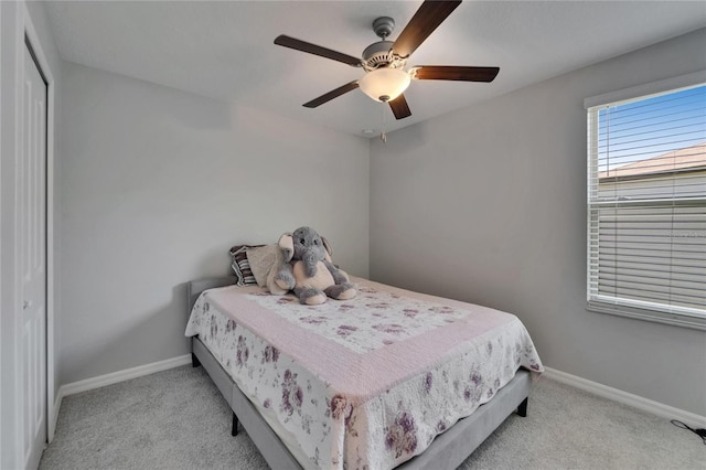 bedroom with a closet, baseboards, a ceiling fan, and carpet floors