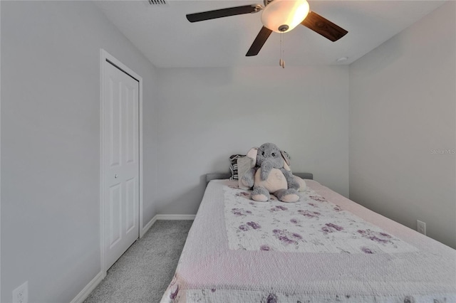 carpeted bedroom with a closet, baseboards, and ceiling fan
