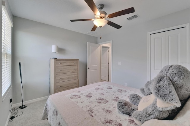 bedroom with baseboards, visible vents, light colored carpet, and multiple windows