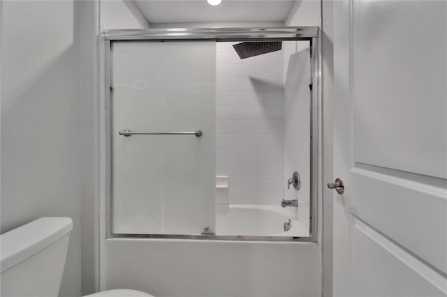 full bathroom with toilet and shower / bath combination with glass door