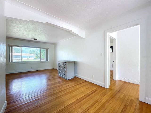 6920 Bougainvilla Ave S, Saint Petersburg, FL 33707 - spare room featuring wood-type flooring, a textured ceiling, baseboards, and crown molding