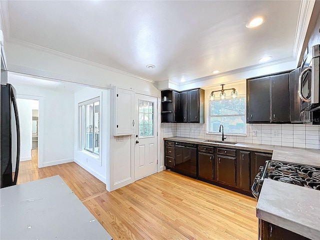 6920 Bougainvilla Ave S, Saint Petersburg, FL 33707 - kitchen with dishwasher, a sink, light countertops, stainless steel microwave, and light wood-style flooring