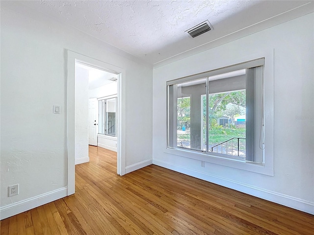6920 Bougainvilla Ave S, Saint Petersburg, FL 33707 - unfurnished room featuring a textured ceiling, wood finished floors, baseboards, and visible vents