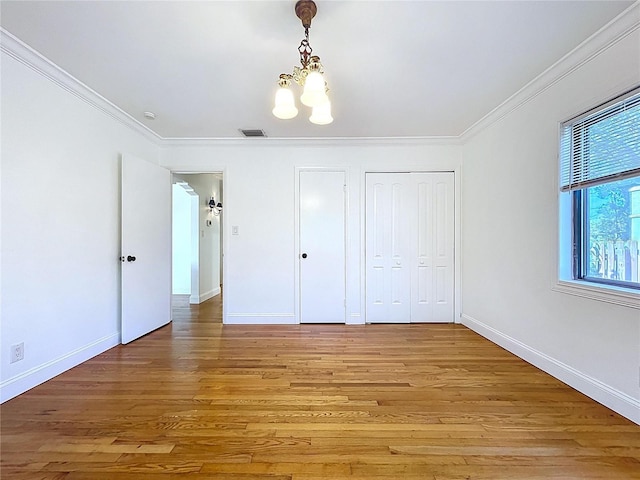 6920 Bougainvilla Ave S, Saint Petersburg, FL 33707 - unfurnished bedroom featuring a chandelier, light wood-type flooring, baseboards, and ornamental molding