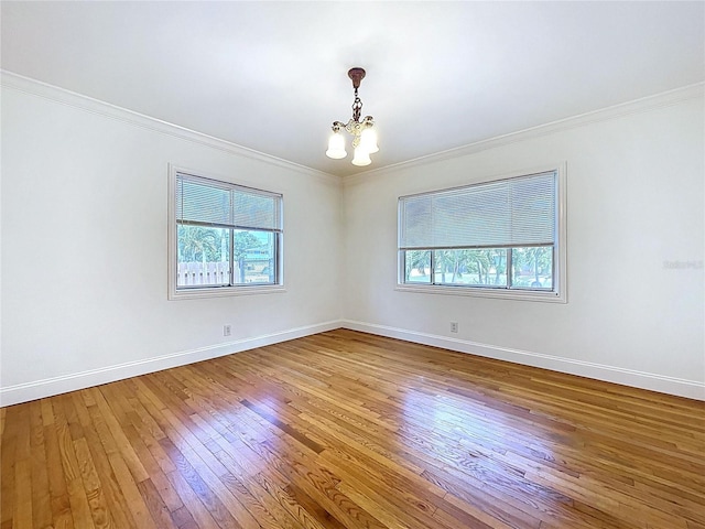 6920 Bougainvilla Ave S, Saint Petersburg, FL 33707 - unfurnished room with hardwood / wood-style floors, an inviting chandelier, baseboards, and ornamental molding