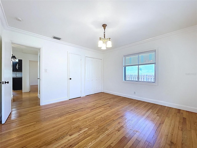 6920 Bougainvilla Ave S, Saint Petersburg, FL 33707 - unfurnished bedroom with baseboards, light wood-type flooring, an inviting chandelier, ornamental molding, and visible vents