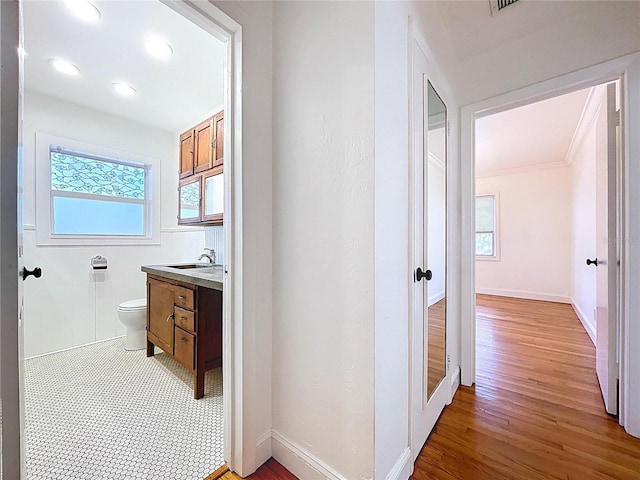 6920 Bougainvilla Ave S, Saint Petersburg, FL 33707 - corridor with light wood-type flooring, french doors, a sink, and baseboards