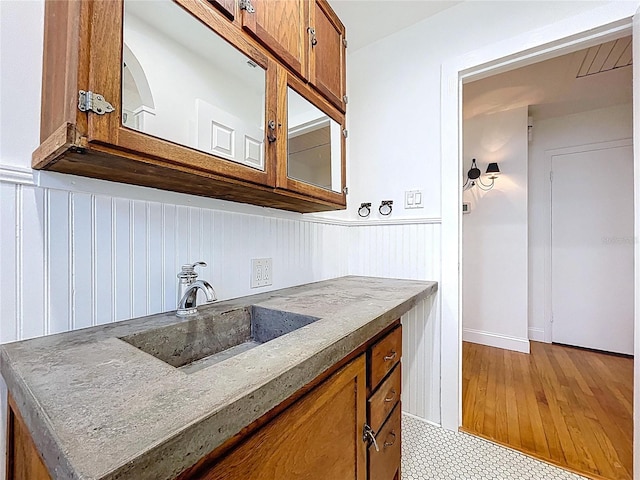 6920 Bougainvilla Ave S, Saint Petersburg, FL 33707 - interior space featuring wainscoting, brown cabinets, and a sink