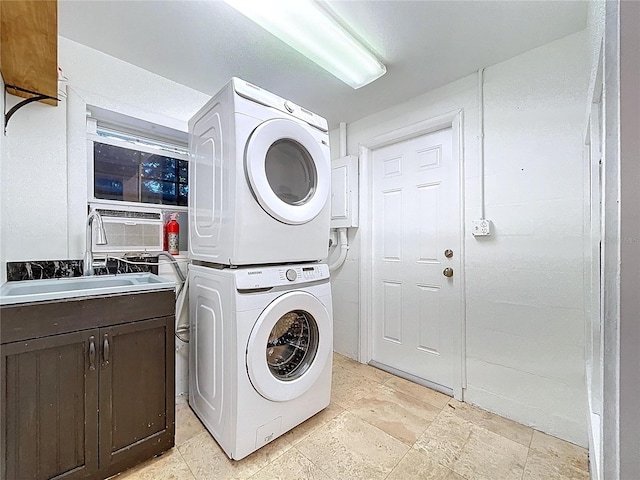 6920 Bougainvilla Ave S, Saint Petersburg, FL 33707 - clothes washing area featuring stacked washing maching and dryer, stone finish floor, a sink, and cabinet space