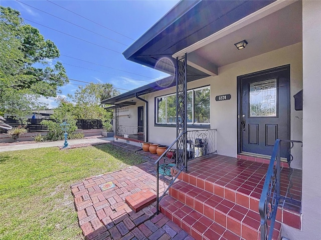 6920 Bougainvilla Ave S, Saint Petersburg, FL 33707 - doorway to property featuring stucco siding and a lawn