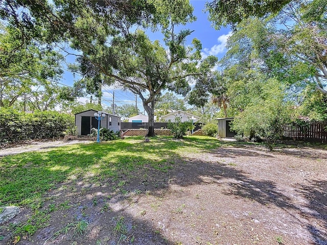 6920 Bougainvilla Ave S, Saint Petersburg, FL 33707 - view of yard featuring a shed, fence, and an outbuilding