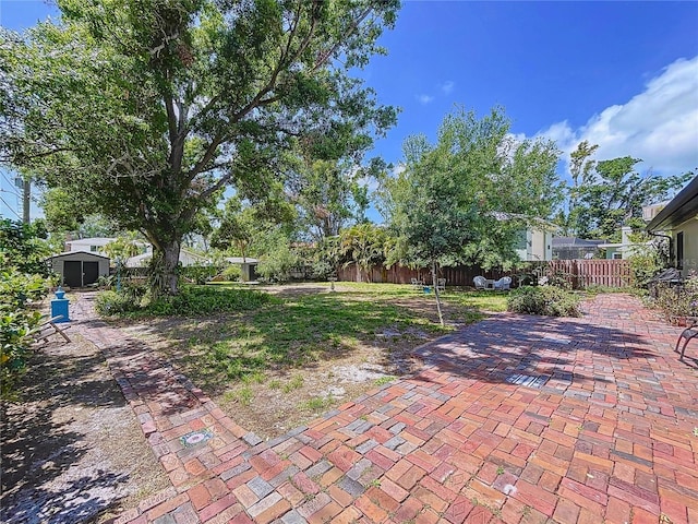 6920 Bougainvilla Ave S, Saint Petersburg, FL 33707 - view of yard with a storage shed, a patio, an outbuilding, and fence