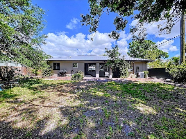 6920 Bougainvilla Ave S, Saint Petersburg, FL 33707 - rear view of property with central AC unit, fence, stucco siding, and a patio area