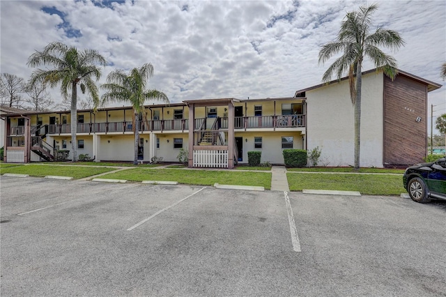 8440 Old Post Rd Unit 104, Port Richey, FL 34668 - view of building exterior with stairway and uncovered parking