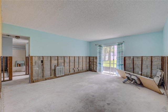 8440 Old Post Rd Unit 104, Port Richey, FL 34668 - unfurnished living room with unfinished concrete floors and a textured ceiling