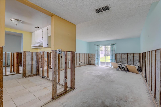 8440 Old Post Rd Unit 104, Port Richey, FL 34668 - hallway with a textured ceiling and a wainscoted wall