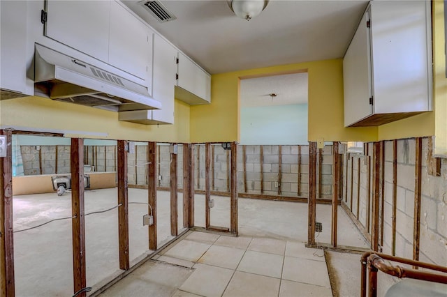 8440 Old Post Rd Unit 104, Port Richey, FL 34668 - kitchen featuring white cabinets and light tile patterned flooring